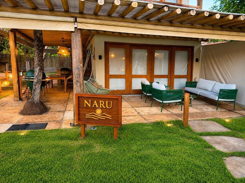 a sign in the grass in front of a patio at Casa Naru in Atins