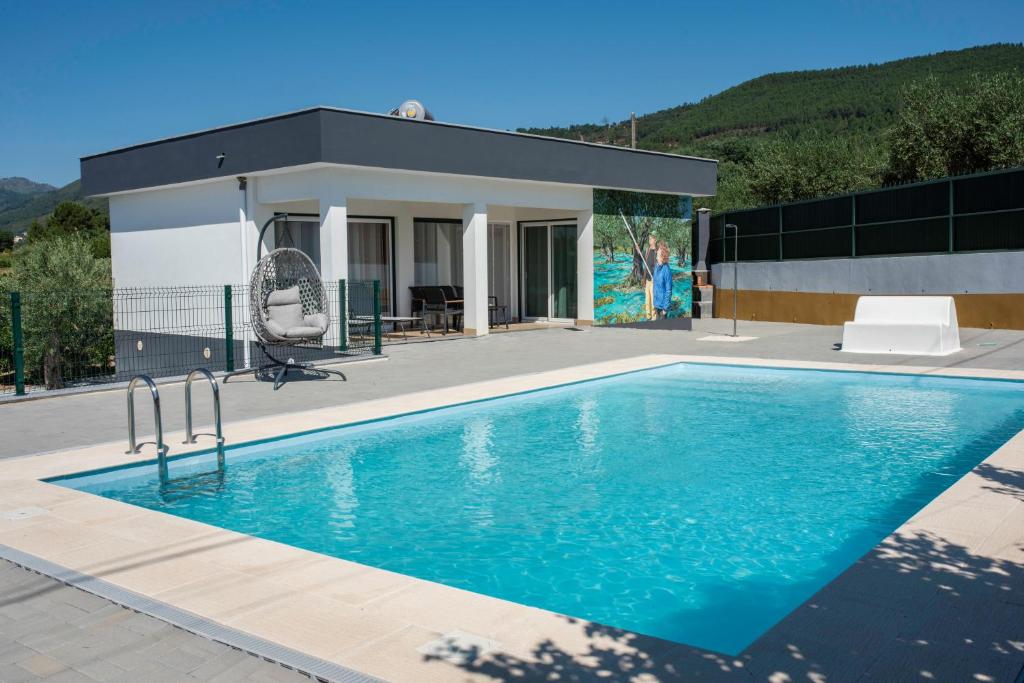 a swimming pool in front of a house at Casa da Quinta da Azeitona 2 - Piscina privada e BBQ na Serra da Gardunha in Fundão