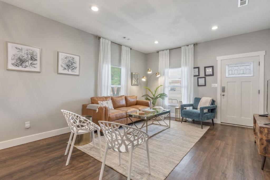 a living room with a couch and a table at Tulsa Boho Bungalow | King Bed• Near Dtwn•EXPO•TU in Tulsa