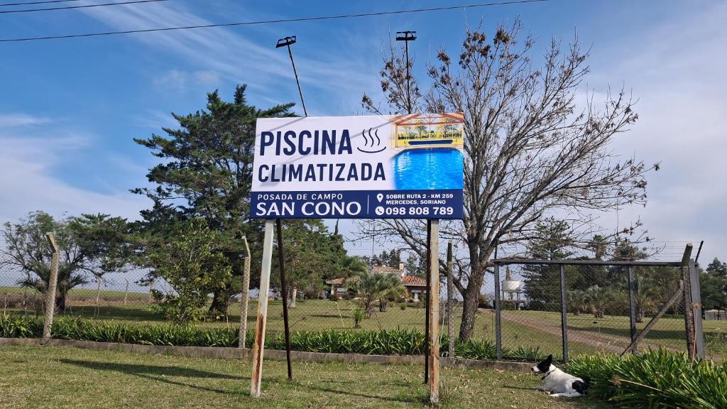 a street sign with a cat sitting next to it at Posada de Campo San Cono in Mercedes