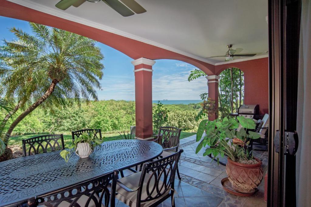 a patio with a table and chairs on a porch at Spacious 4BR Condo with Partial Ocean View - Bougainvillea - Reserva Conchal in Playa Conchal