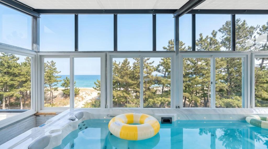 an indoor swimming pool with a large glass wall at Samcheok Migaloo Pool Villa Pension in Samcheok
