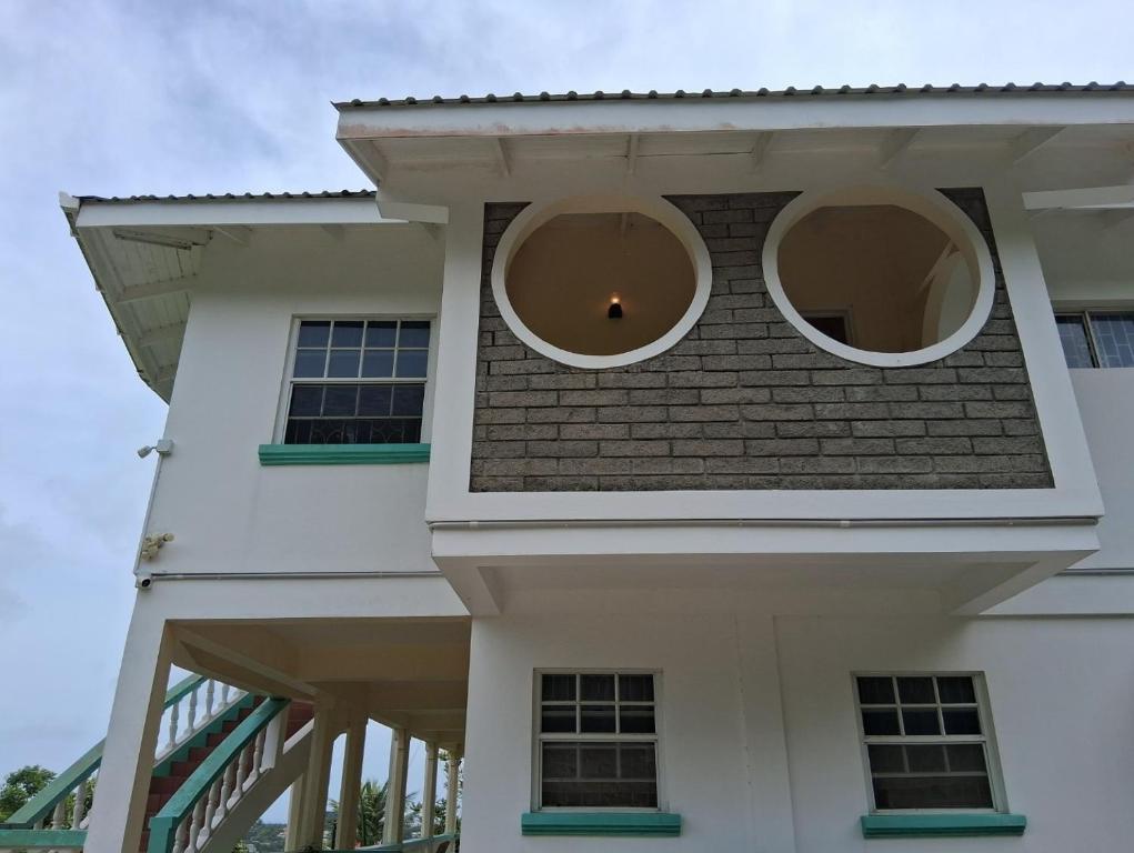 a white house with two round windows on it at Nyack's Palace And Boutique in Beaulieu