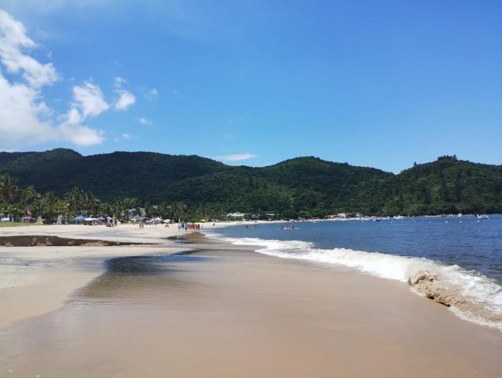 Una playa con mucha gente y el océano. en Pousada Costa Verde Tabatinga, en Ubatuba