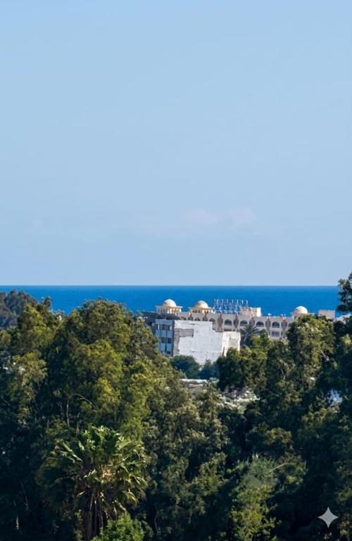 a building in the middle of a bunch of trees at Hammamet villa Bleu in Hammamet
