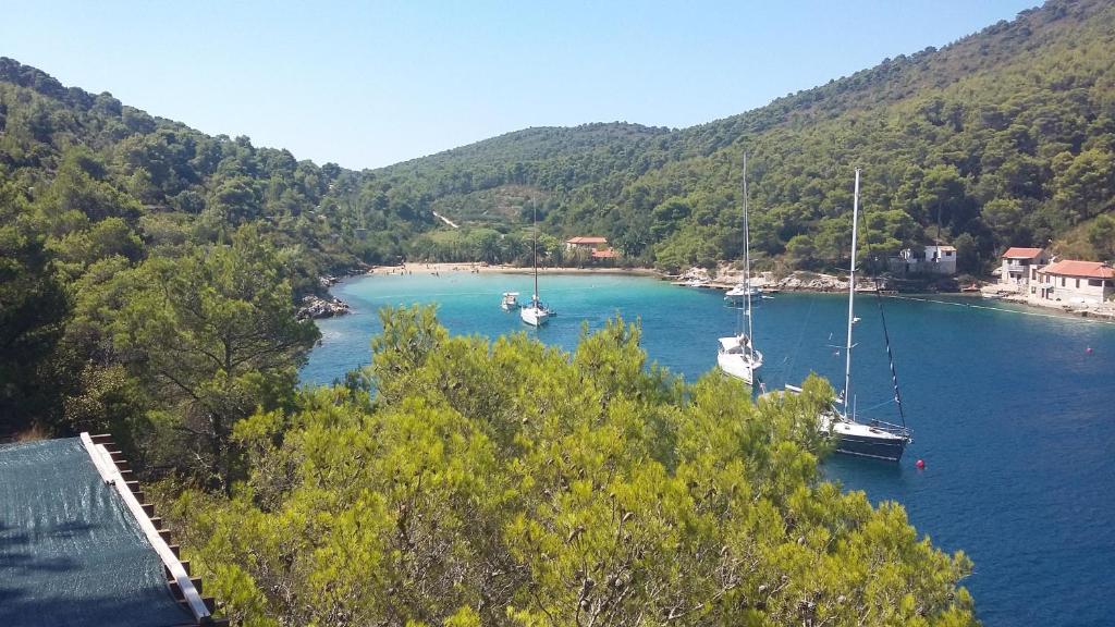 two boats are docked in a river with mountains at Apartment Nono Ivo in Vis