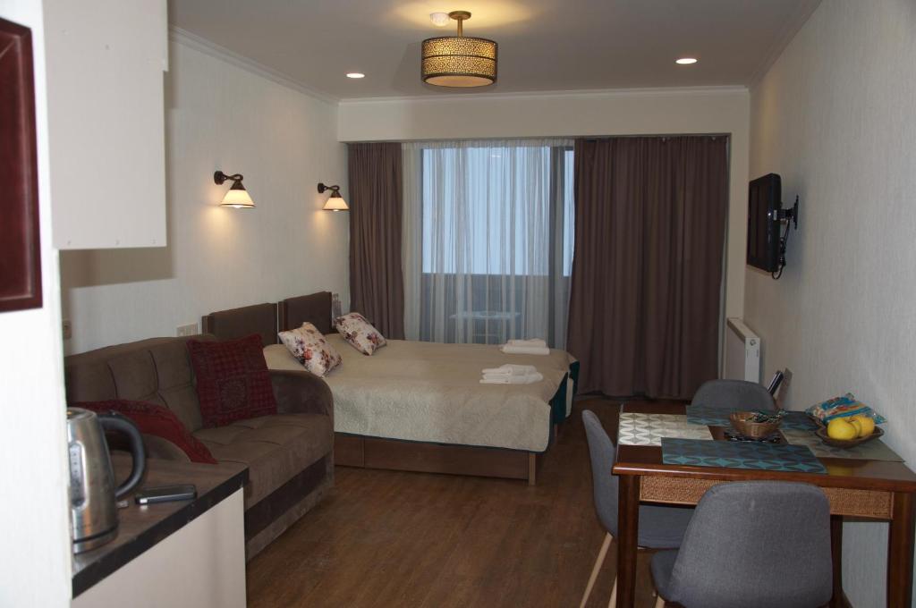 een woonkamer met een bank en een bed in een kamer bij New Gudauri Studio 222 in Goedaoeri