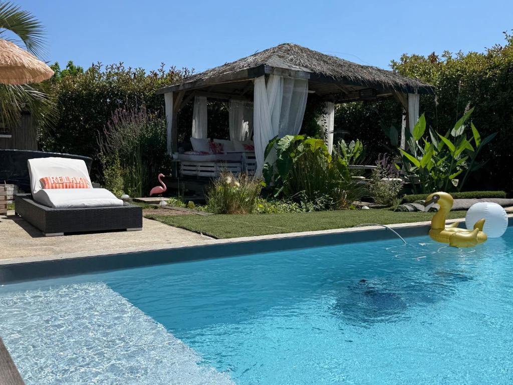 a swimming pool with a toy duck in the water at L Effet Mer Cocon climatisé avec terrasse et jardin privés Piscine in Audenge