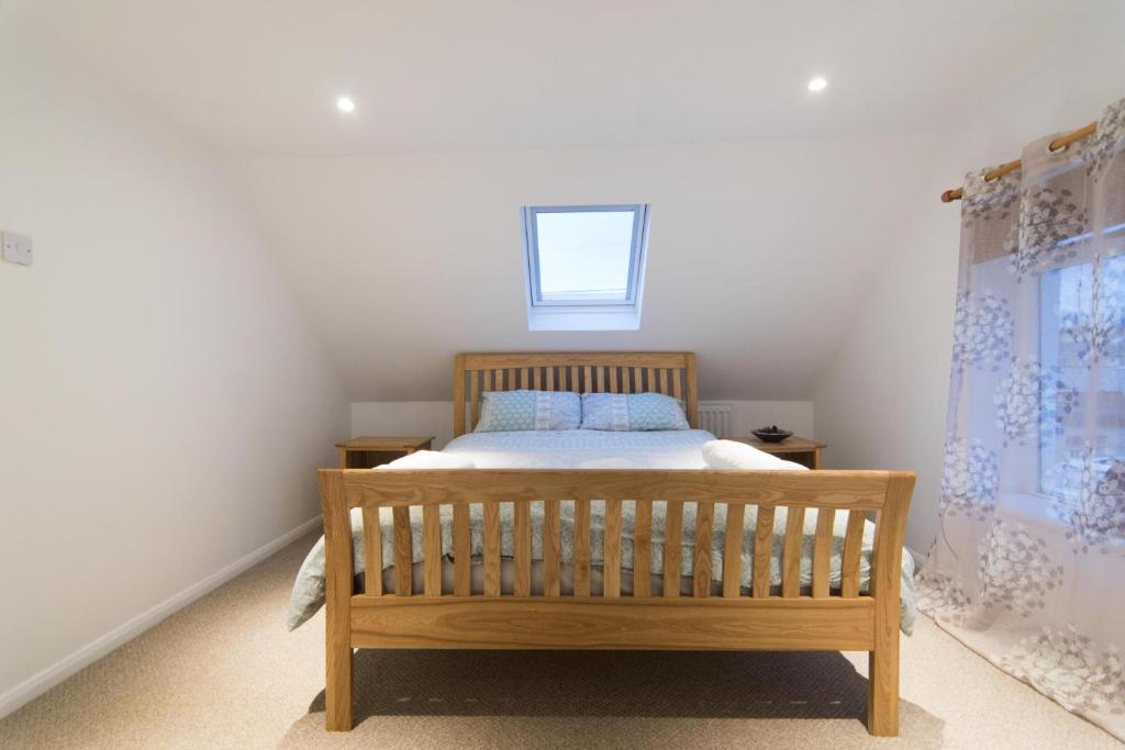 a bedroom with a wooden bed and a window at Blair Drummond Holiday Home in Doune