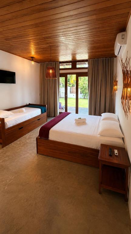 a large bedroom with two beds and a window at Bossa Atins in Atins