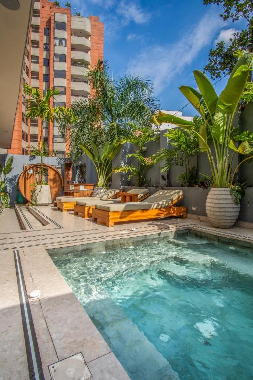 a swimming pool with chairs and a building at Veca Flats Centenario in Cali
