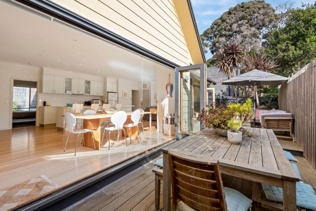 an open living and dining room with a wooden table at Kassandra in Point Lonsdale