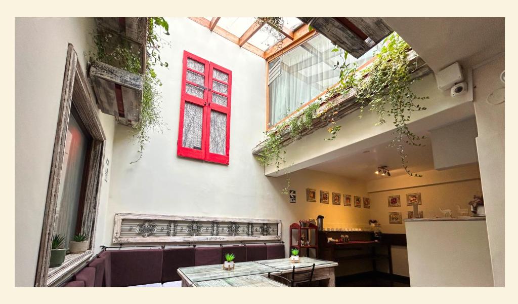 a room with a red window and a table at Wakapunku Boutique B&B in Cusco