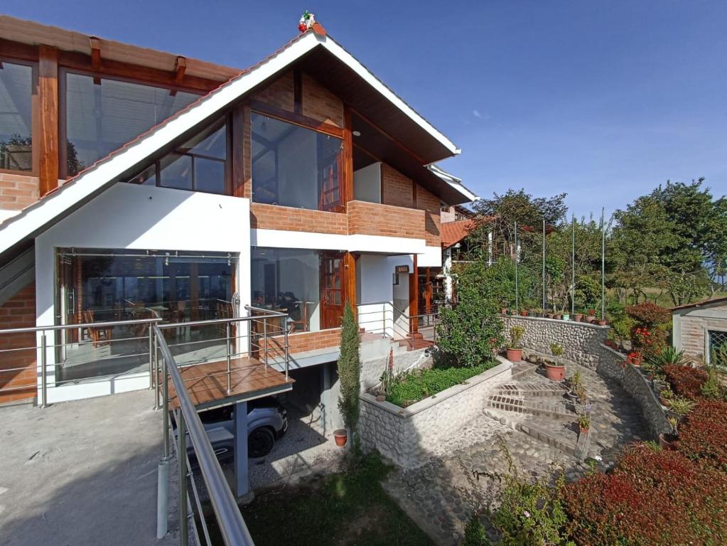 a house with a large window and a porch at Hosteria Chyrywasy Home in Ibarra
