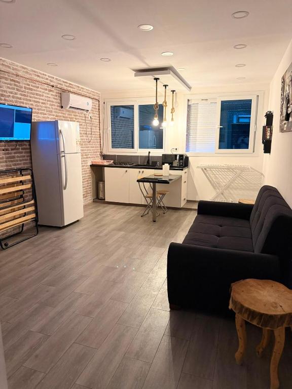 a living room with a couch and a kitchen at Elegant Studio - Ideal for Couples in Mazagran