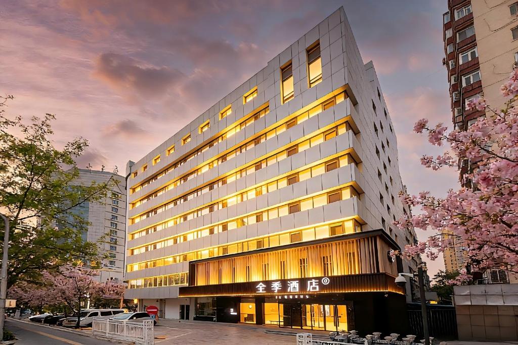 a large building with lights on in a city at JI Hotel Beijing Panjiayuan in Beijing