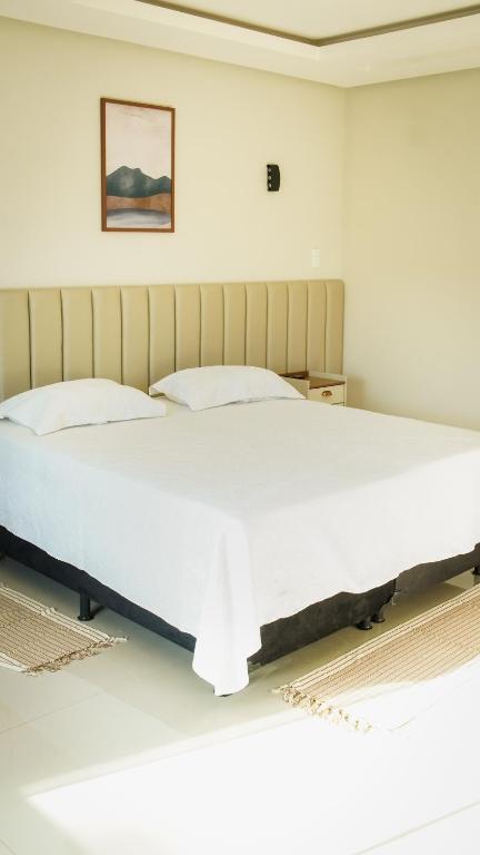 a bedroom with a large bed with a white bedspread at Pousada Acessus Executivo - Cozinha e Lavanderia in Anápolis