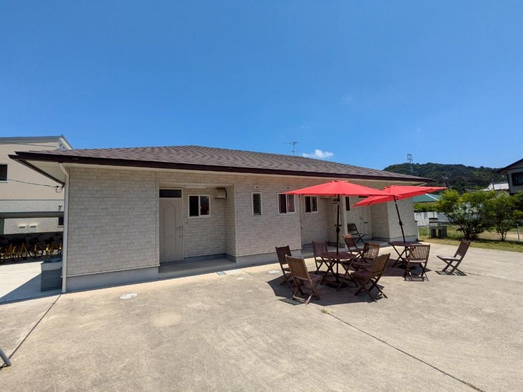 a patio with tables and umbrellas in front of a building at La Curación in Naoshima