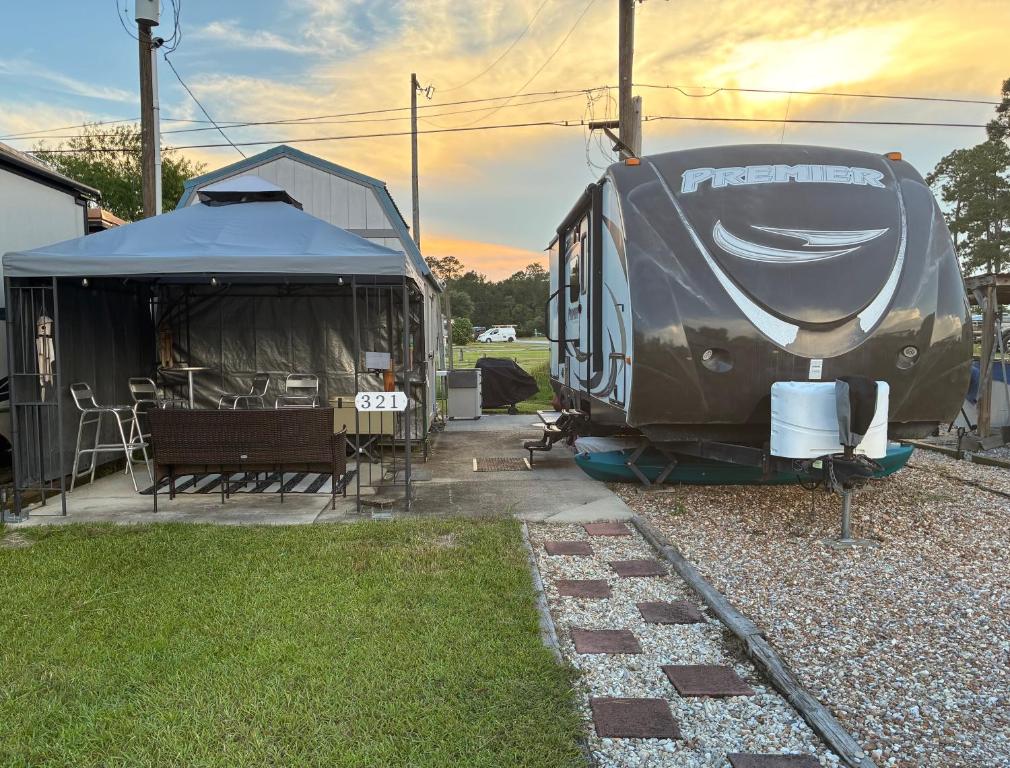 a camper and a tent in a yard at My Little RV Getaway in Pass Christian