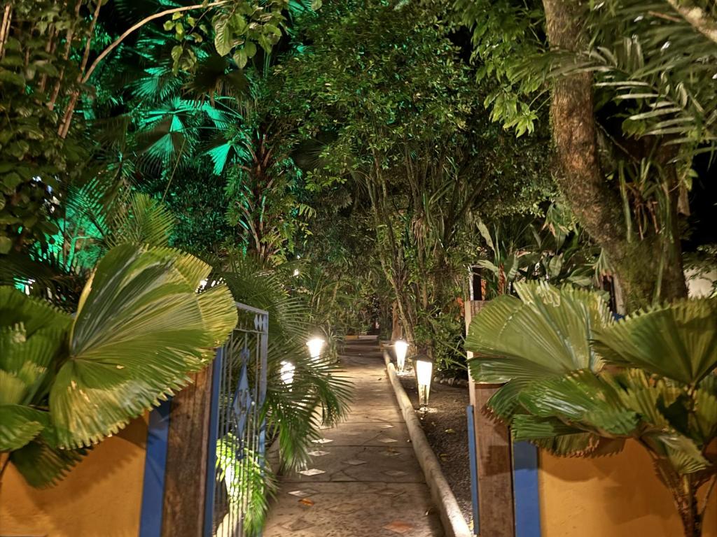 a garden with a fence and trees and lights at Pousada Bemvirá in Arraial d'Ajuda