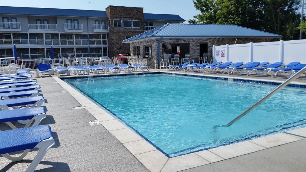 a large swimming pool with blue chairs and chairs at Put-in-Bay Condos in Put-in-Bay