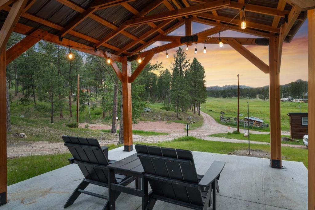 a patio with two chairs and a table with a view at The Monet- BHBungalows #1 in Custer