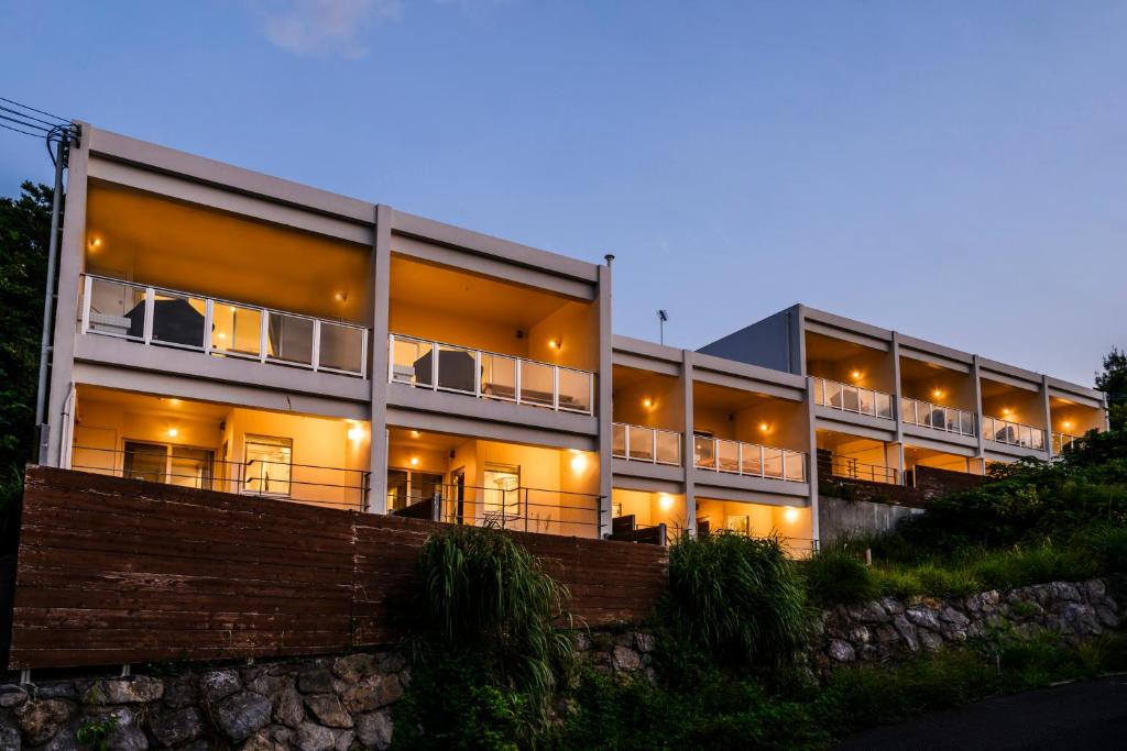 a large building with lights on it at night at Hillside Sea View Resort Villa Gushikumui in Motobu