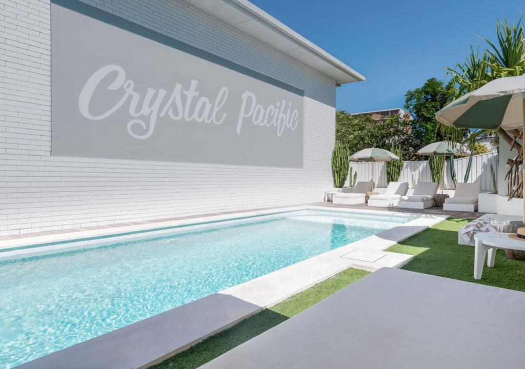a swimming pool with a sign on the side of a house at Crystal Pacific Palm Beach in Gold Coast