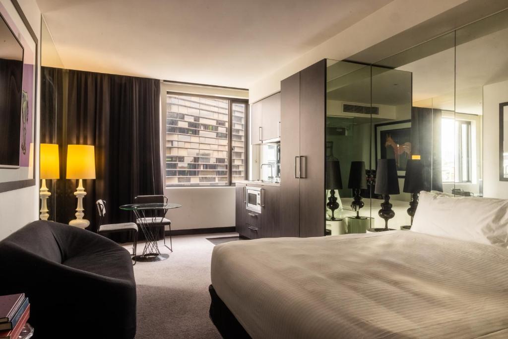 a hotel room with a bed and a chair at Elli Prahran in Melbourne