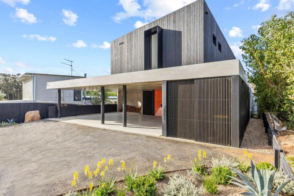 a modern house with a black facade at Betula in Tilba Tilba