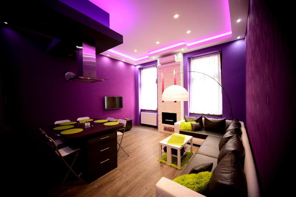 a purple living room with a couch and a table at Hernad Apartment in Budapest