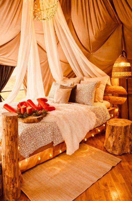 a bed in a tent with a bowl of fruit on it at Lepiej trafić nie mogliście in Unisław Śląski