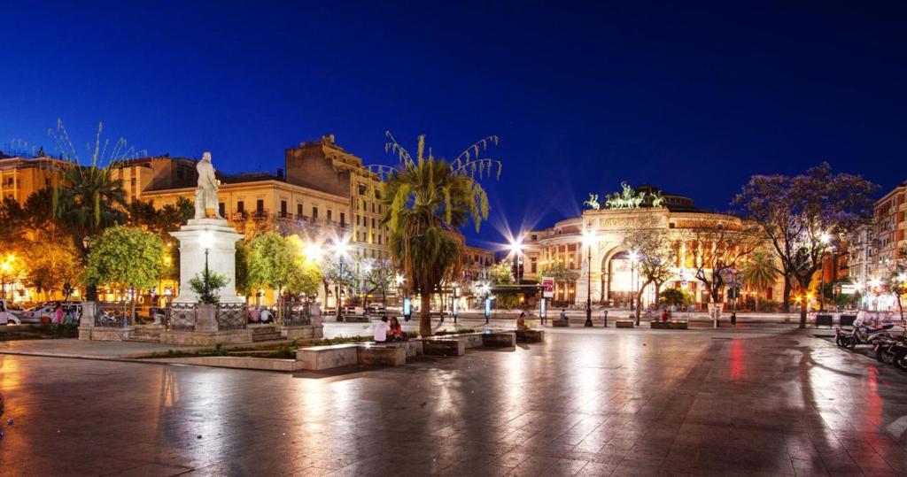 a city square at night with buildings at CasaLù in Palermo