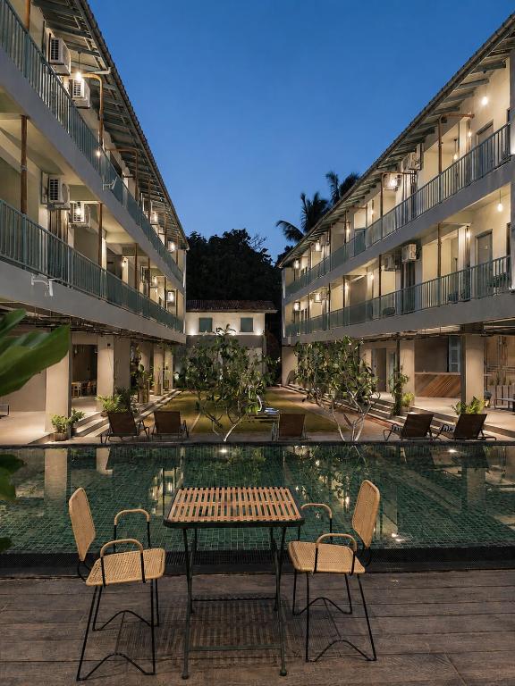 a table and chairs in front of a building at Grids by Epic Collection in Unawatuna
