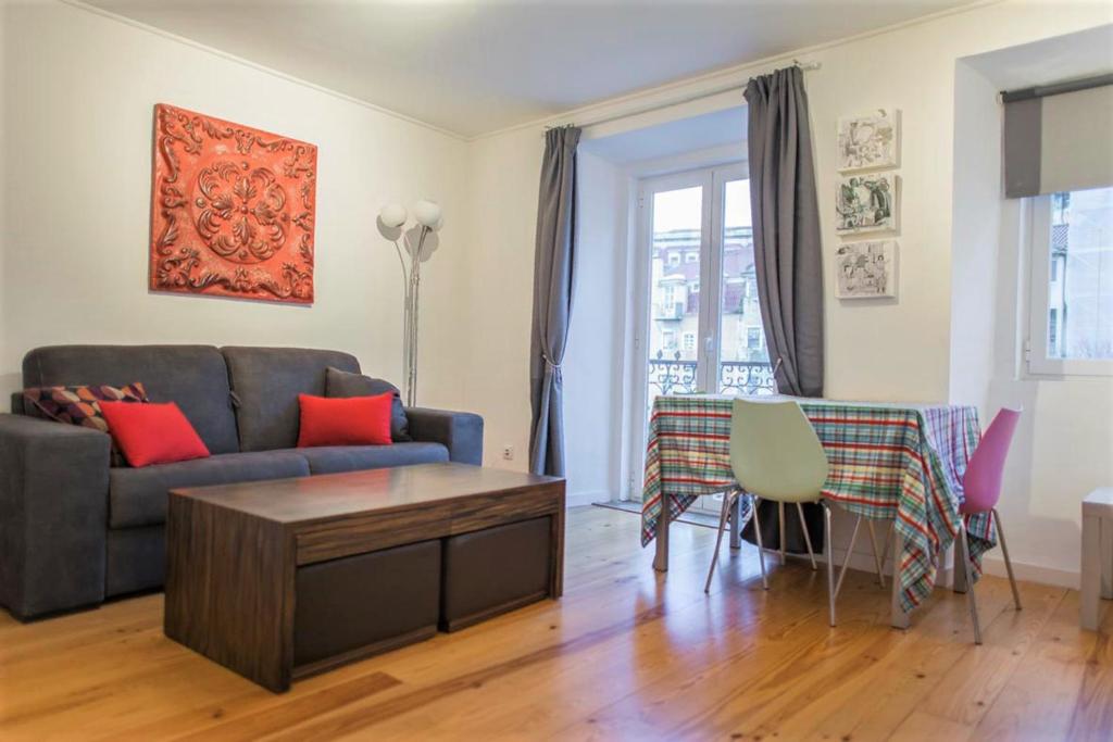 een woonkamer met een bank en een tafel bij Apartamento Mártires da Pátria in Lissabon