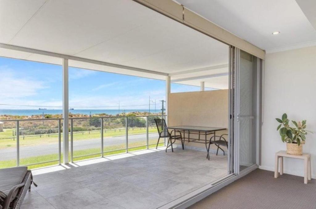 an open living room with a table and a balcony at Ocean Views in Rockingham