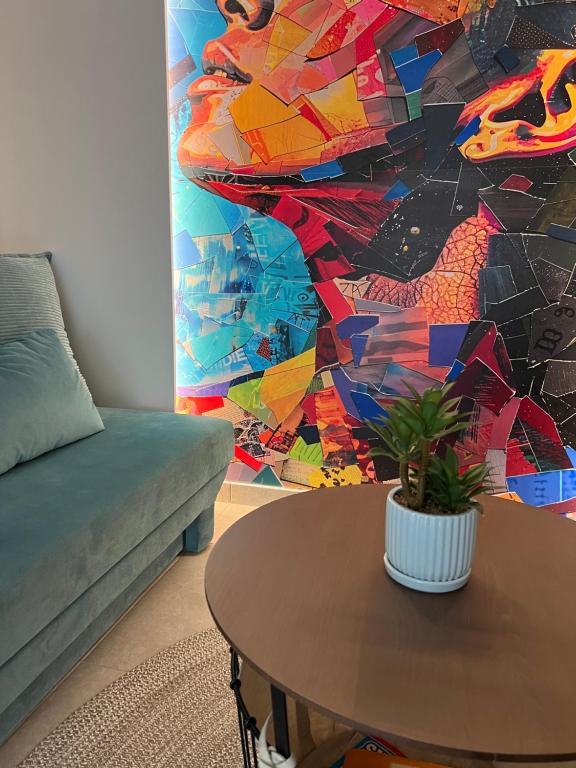 a living room with a table and a mosaic wall at Madi apartment in Veria