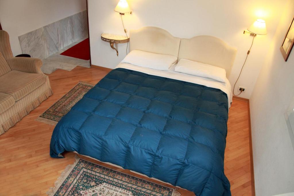 - une chambre avec un grand lit bleu dans l'établissement B&B Da Gilberto, à Cividale del Friuli