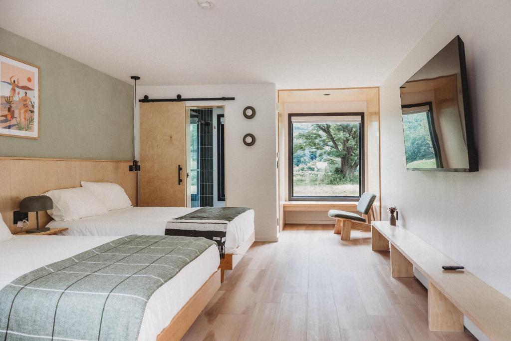 a hotel room with two beds and a window at Otherland Hotel in Newfane