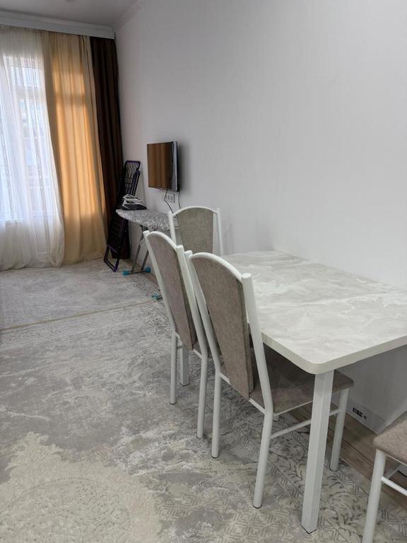 a white table and chairs in a room at Квартира студия in Bosteri