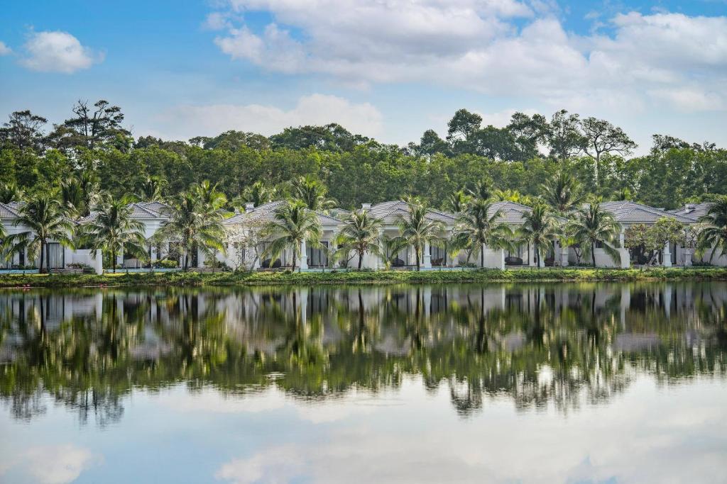 a resort with palm trees in front of a body of water at Meliá Vinpearl Phu Quoc in Phú Quốc