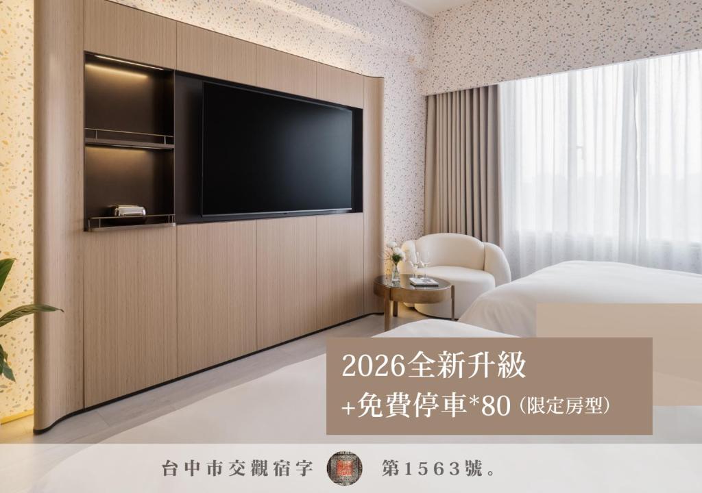 a hotel room with a television on a wall at T Hotel in Taichung