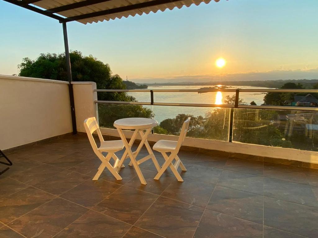 a table and two chairs on a balcony with the sunset at Villa Magdalena y Puerto Perales in La Piedad