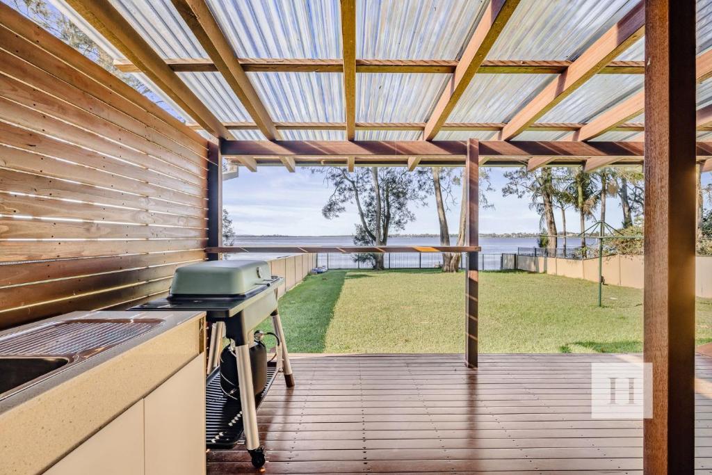 an outdoor kitchen with a grill and a view of the ocean at Sunrise Waters in Gorokan