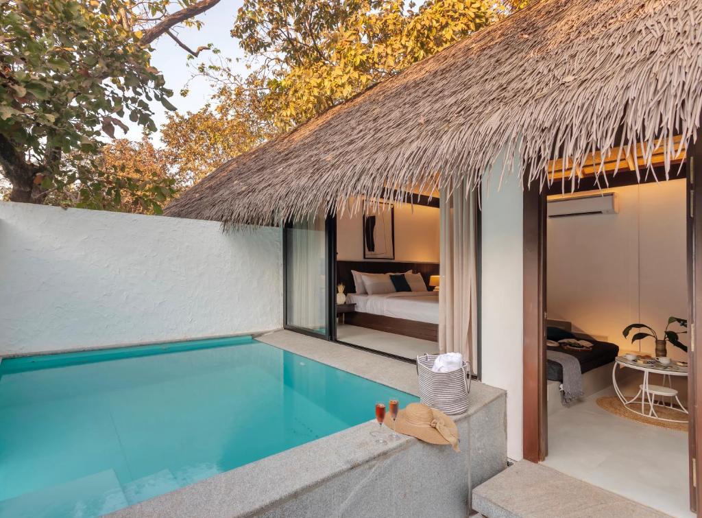a villa with a swimming pool and a bedroom at OIA GOA - Private Pool in Vagator