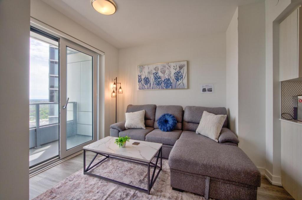 a living room with a couch and a table at Cozy Condo in Downtown KW in Kitchener