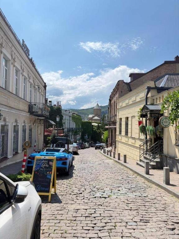 a cobblestone street in a city with cars parked at Apart Hotel Banovani in Tbilisi City