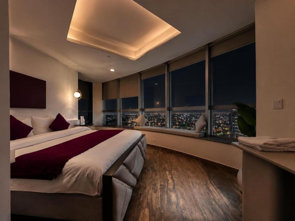 a bedroom with a large bed with a view of the city at Whispers above the city 2Bhk Centaurus Mall pool Gym City view in Islamabad