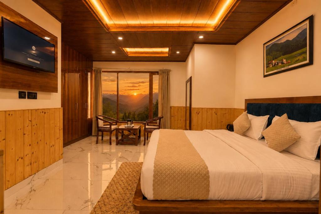 a bedroom with a bed and a table and a television at The Dogri Boutique Cottage, Mashobra - Luxury Cottage with Scenic mountain view in Shimla