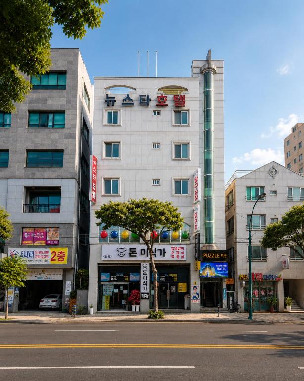 a tall white building on a city street at New Star Hotel in Chu-sung